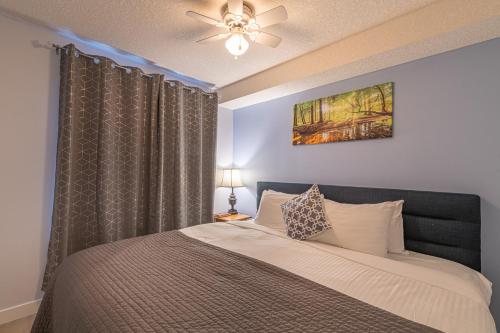 - une chambre avec un lit et un ventilateur de plafond dans l'établissement Mountain View One Bedroom Vacation Suite - WindTower 119, à Canmore