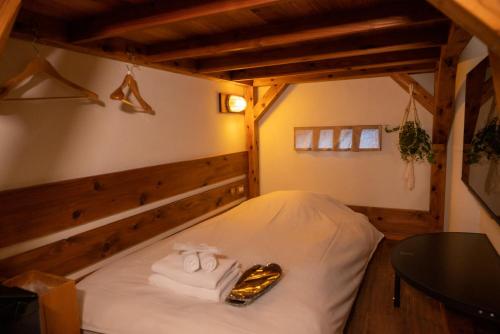 una camera con un letto con asciugamani e un tavolo di GOOD MORNING ZAIMOKUZA a Kamakura