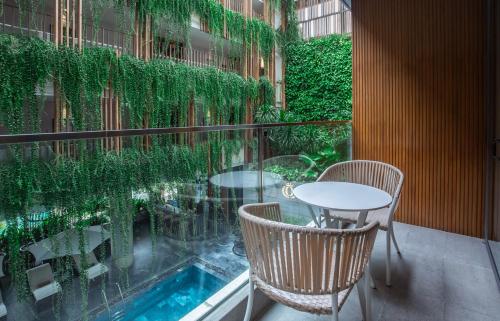 a balcony with a table and chairs and plants at New Orient Hotel Da Nang in Da Nang