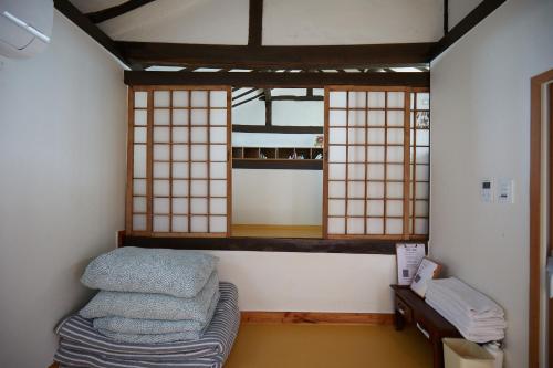 a room with a bed and two windows in it at Bonghwangjae Hanok Guesthouse in Gongju