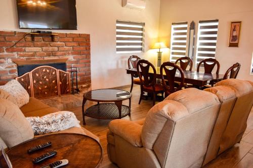 a living room with a couch and a table and a fireplace at Finca Selah in Ensenada