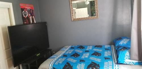 a bedroom with a bed and a flat screen tv at Cozy 6 bedroom home with Gameroom and Fire pit. in Rawsonville