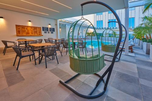 a swing in a restaurant with tables and chairs at City Express Plus by Marriott Mexicali in Mexicali