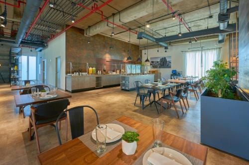 a restaurant with tables and chairs and a kitchen at City Express Plus by Marriott Mexicali in Mexicali