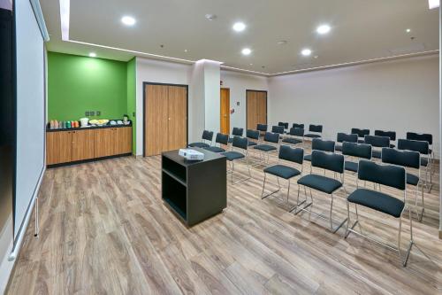 a conference room with chairs and a table and a counter at City Express Plus by Marriott Mexicali in Mexicali