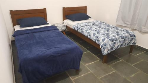 two beds sitting next to each other in a room at Quarto com duas camas de solteiro in Itu