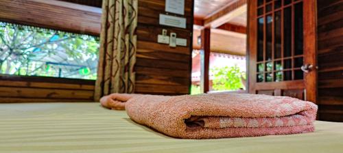 a pink towel laying on top of a bed at My dream house resort in Jomtien Beach