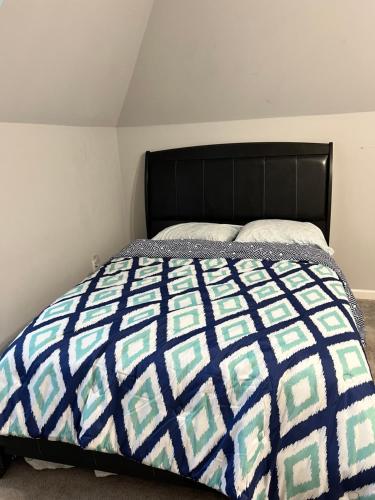 een slaapkamer met een bed met een blauwe en groene quilt bij Cozy unit in Conyers