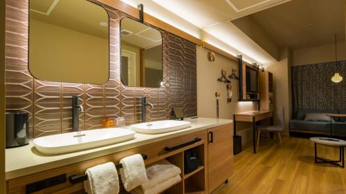 小樽市にあるGRIDS PREMIUM HOTEL OTARUのバスルーム(シンク2台、大きな鏡付)