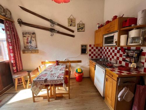 une cuisine avec une table et une cuisine avec une cuisinière dans l'établissement Châtel, apt 2p, 4 pers, balcon, ski, parking - FR-1-198-260, à Châtel