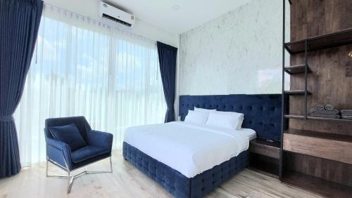 - une chambre avec un lit et une chaise bleue dans l'établissement Green Lung Pool Villas Bangkok, à Bang Krasop