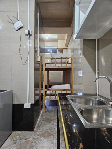 a kitchen with a sink and a bunk bed at The Gather Inn Room Rentals - Baguio City in Baguio