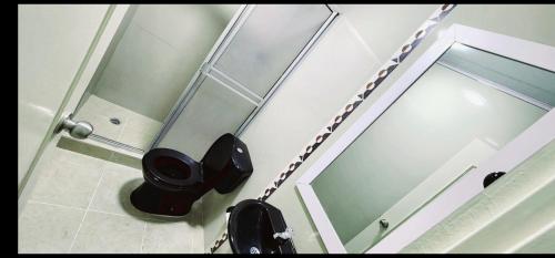a bathroom with a toilet and a glass shower stall at Excelente Apartamento Confortable, Central, Bonito y Económico in Espinal
