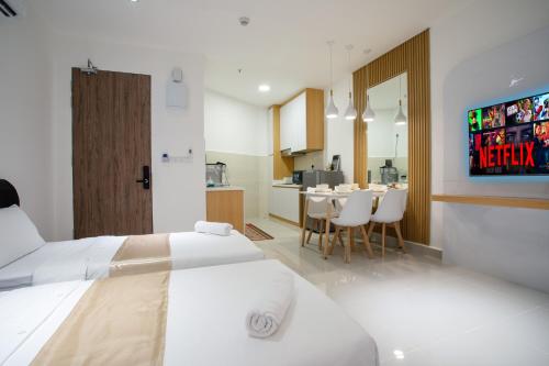 ein Schlafzimmer mit 2 Betten und eine Küche mit einem Tisch in der Unterkunft Just Chillin Pool & Seaview Suites in Kota Kinabalu