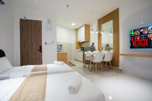 a bedroom with two beds and a kitchen with a table at Just Chillin At The Shore Pool & Seaview Suites in Kota Kinabalu