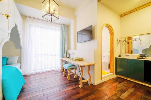 Cette chambre dispose d'une table, d'un lavabo et d'une salle de bains. dans l'établissement Lacasa May, à Đà Lạt
