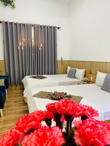 two beds in a hotel room with red flowers at Khách sạn Trọng Thiêm 1 in Ấp Thiện Lập