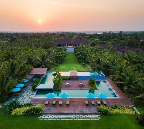 einen Luftblick auf einen Pool mit Sonnenschirmen des Resorts in der Unterkunft Aprota Villas Arugambay in Arugam Bay