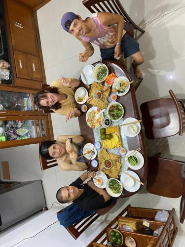 a group of people standing around a table with food at Lu Peaceful Homestay in Da Nang