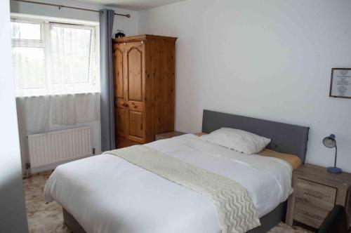 ein Schlafzimmer mit einem Bett, einer Kommode und einem Fenster in der Unterkunft Quiet 2 Bedroom house for holiday let in Gravesend in Kent