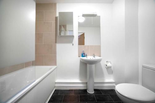 a bathroom with a sink and a toilet and a tub at 3BR Apartment Ideal for 6, Near London Museums in Colindale