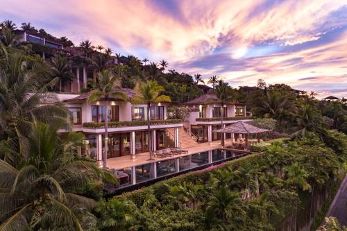 an aerial view of a house on a hill with palm trees at Andara Resort Villas in Kamala Beach