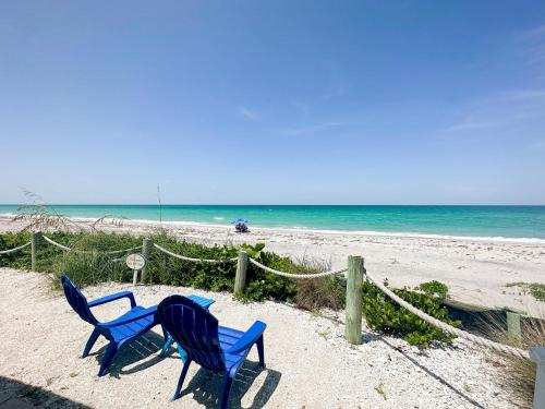 恩格爾伍德的住宿－The Pearl Beach Inn，两把蓝色椅子坐在海边