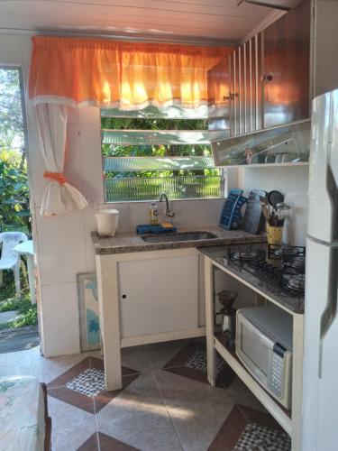 une cuisine avec un évier et un plan de travail dans l'établissement Kitconforto, à Guarujá
