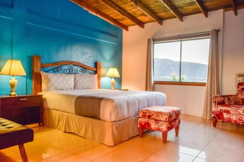 1 dormitorio con 1 cama con pared azul en Finca Selah, en Ensenada