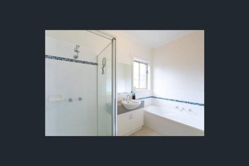 Ванна кімната в Comfortable 3-bedroom home with two car garage