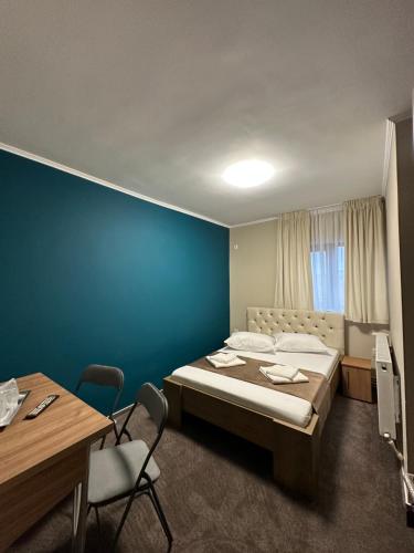 1 dormitorio con cama y pared azul en Freedom&Relax, en Buzău