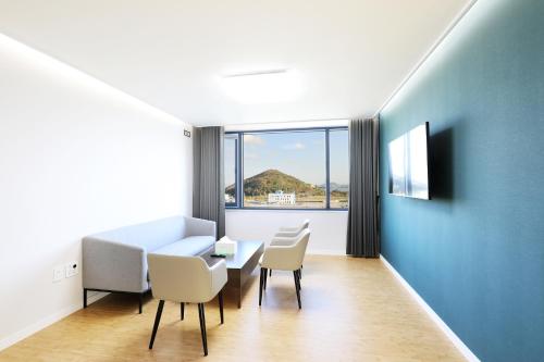 a room with a table and chairs and a blue wall at Mokpo Ocean Hotel in Mokpo