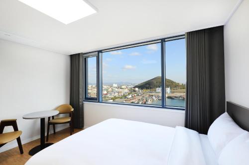 ein Hotelzimmer mit einem Bett und einem Fenster in der Unterkunft Mokpo Ocean Hotel in Mokpo