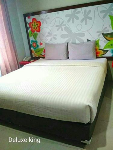 a bedroom with a large bed with a white mattress at HOTEL SYARIAH GRAND JAMEE in Sunggal