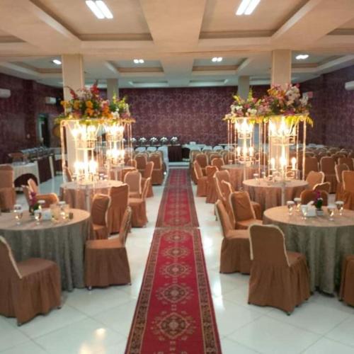 a large banquet hall with tables and chairs at HOTEL SYARIAH GRAND JAMEE in Sunggal