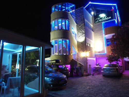 een gebouw waar 's nachts auto's voor geparkeerd staan bij Apartments and bungalows vila Dalibor in Nin