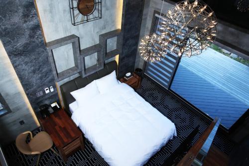 a bedroom with a white bed and a chandelier at Elin Village in Seogwipo