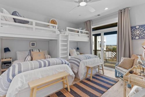 a bedroom with two bunk beds and a balcony at SeaSons at the Point in Oak Island