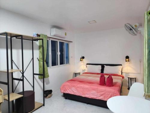 een slaapkamer met een bed met een rode deken bij Baan Sabaijai Viking Home in That Phanom
