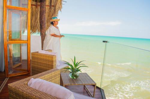 a woman standing on a balcony with a fishing line at RCH LUXURY HOTEL & POOL in Dibulla