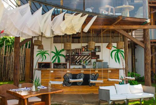 a patio with a table and chairs and umbrellas at RCH LUXURY HOTEL & POOL in Dibulla