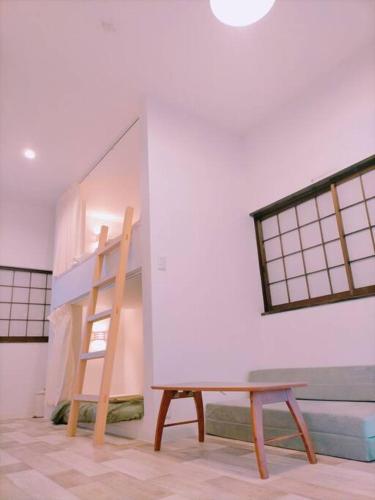 um quarto com um beliche e uma escada em LILY's House em Sano