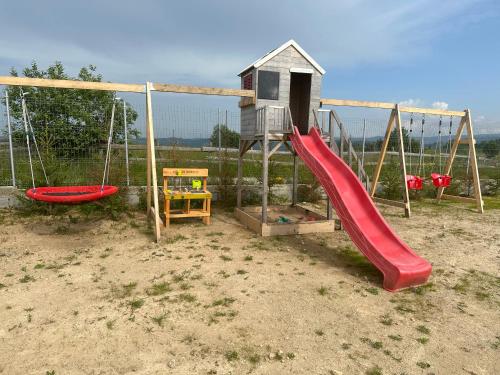 un parco giochi con scivolo rosso e struttura per giochi di Mariseltinyhouse a Mărişel