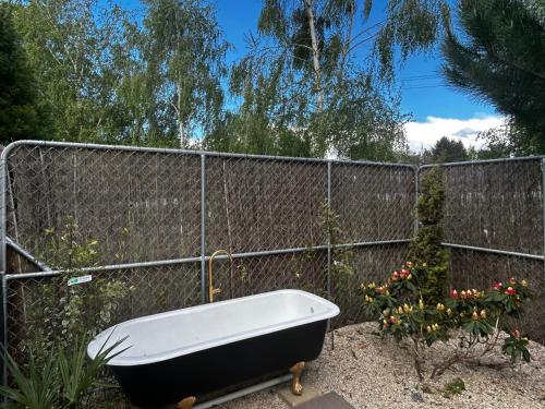 a bath tub sitting in front of a fence at Benger Garden Chalets in Millers Flat