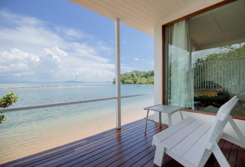 a porch with a white bench and a view of the water at Seashell Village Resort in Chao Lao Beach