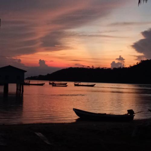 a group of boats on the water at sunset at Bong's Guesthouse M'Pai Bay in Koh Rong Sanloem