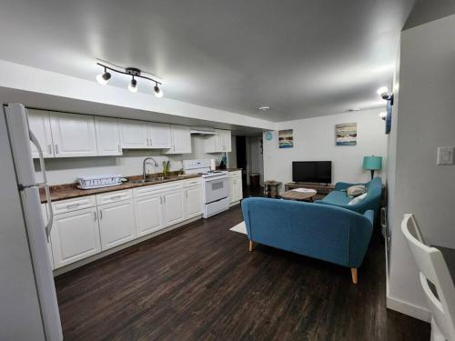a living room with a blue couch and a kitchen at TheAuroras: Vibrant&Cheerful 2 bdrm Stylish suite in Saskatoon