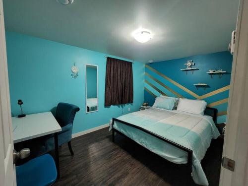 een blauwe kamer met een bed en een bureau bij TheAuroras: Vibrant&Cheerful 2 bdrm Stylish suite in Saskatoon