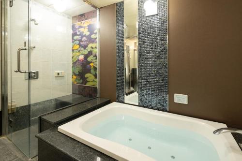 a bathroom with a tub and a glass shower at ホテル ブルジュア 久留米 Hotel Bvljua -レジャーホテル- in Kurume