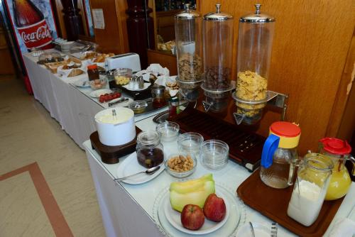 a buffet line with food and drinks and fruit on plates at Elegant Beach Hotel - former Hotel Tsolaridis in Kyparissia